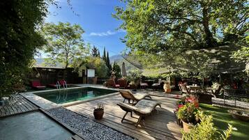 Relax by the serene pool surrounded by lush greenery and trees.