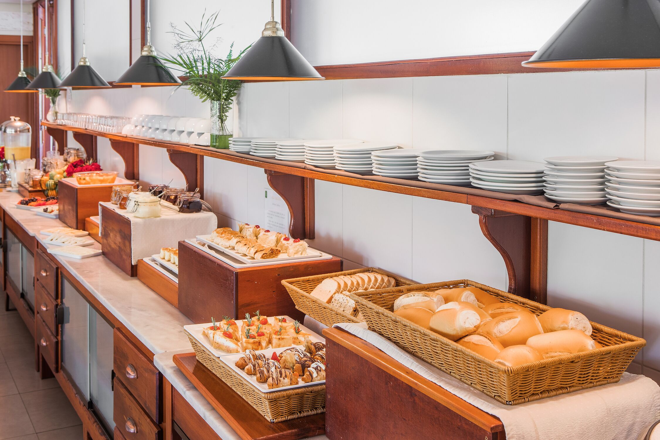 A buffet setup with various food items and plates.