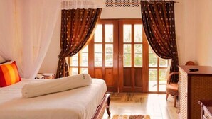 Un dormitorio con cama, cortinas, una ventana y una silla.