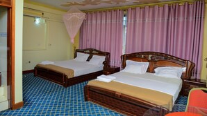 A hotel room with two wooden beds, a blue checkered floor, and a pink curtain. - JBK Hotel (Kampala)