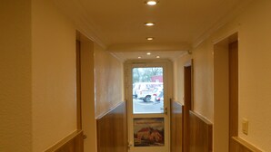 A hallway with wooden paneling and a door at the end. - Hotel Zum großen Krug (Wirdum)