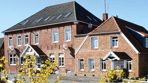 A large brick building with multiple windows and a sloped roof. - Hotel Zum großen Krug (Wirdum)