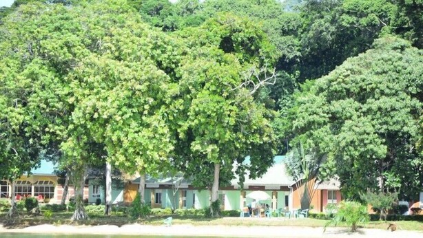 A beachfront hotel with multiple buildings, a sandy beach, and a body of water. - Mirembe Resort Beach Hotel (Bugala Island)