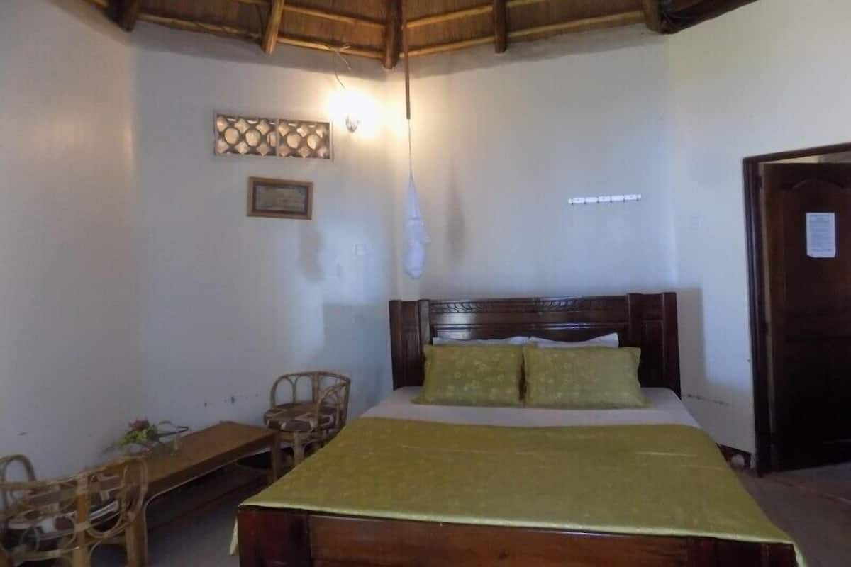 Un dormitorio con una cama de madera, un escritorio y una silla.