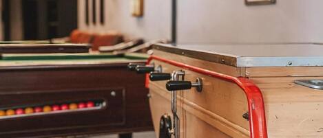A pool table with a wooden side table and a red edge.