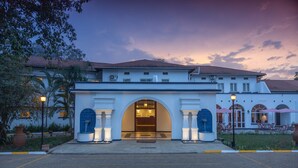 L’entrée de l’hôtel se caractérise par une arche centrale, un comptoir d’accueil et un patio agrémenté de sièges extérieurs.
