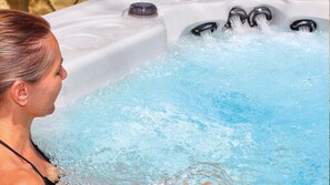 Una persona en un jacuzzi con múltiples chorros de agua.