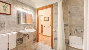 A bathroom with a sink, mirror, and shower area. - Hotel Gea di Vulcano (Rome)