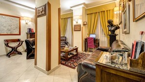 A well-furnished living room with a leather sofa, a coffee table, and a bookshelf. - Hotel Gea di Vulcano (Rome)