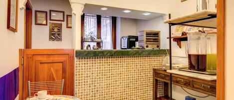 Una cocina acogedora con salpicadero de azulejos, armarios de madera y un rincón comedor con una mesa preparada para dos.
