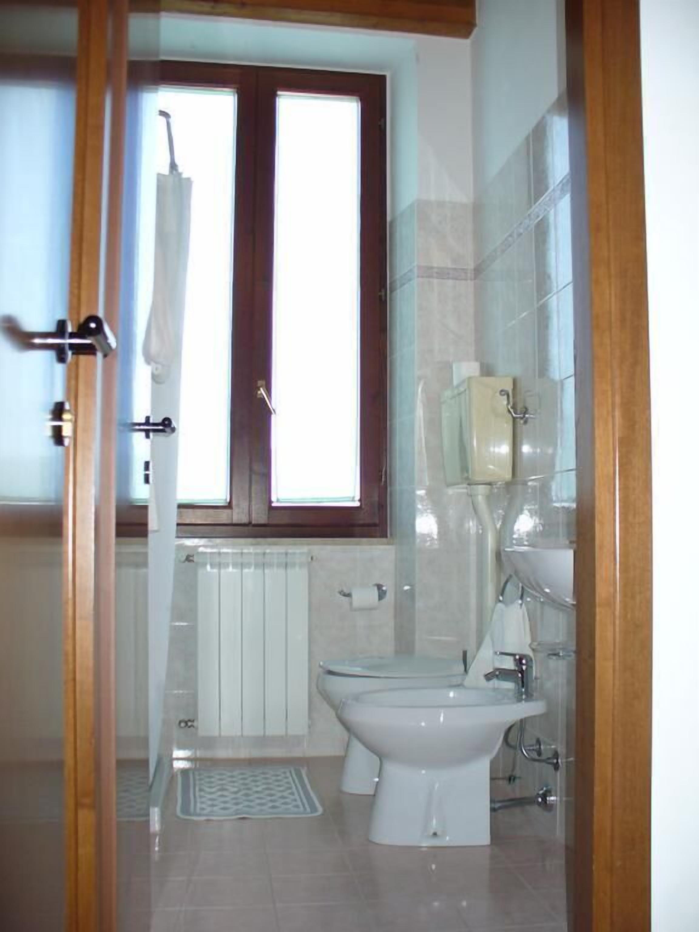Un bagno con il water, bidet e una finestra.