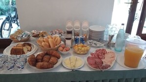 Un buffet de petit-déjeuner proposant une variété d’aliments, notamment des viennoiseries, des fruits et des boissons.