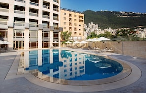 Seasonal outdoor pool, open 10:00 AM to 6:00 PM, pool umbrellas