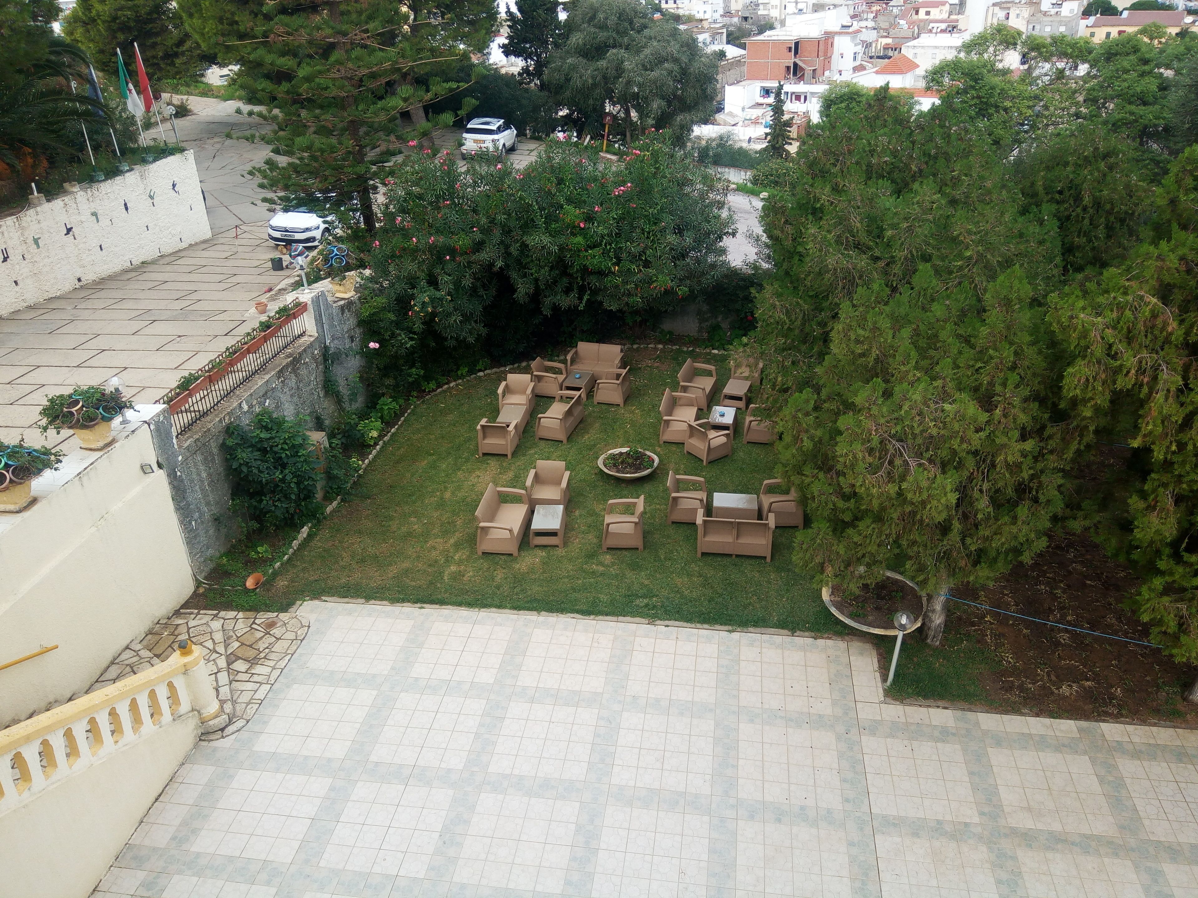 Un patio con mobiliario exterior y un área pavimentada.