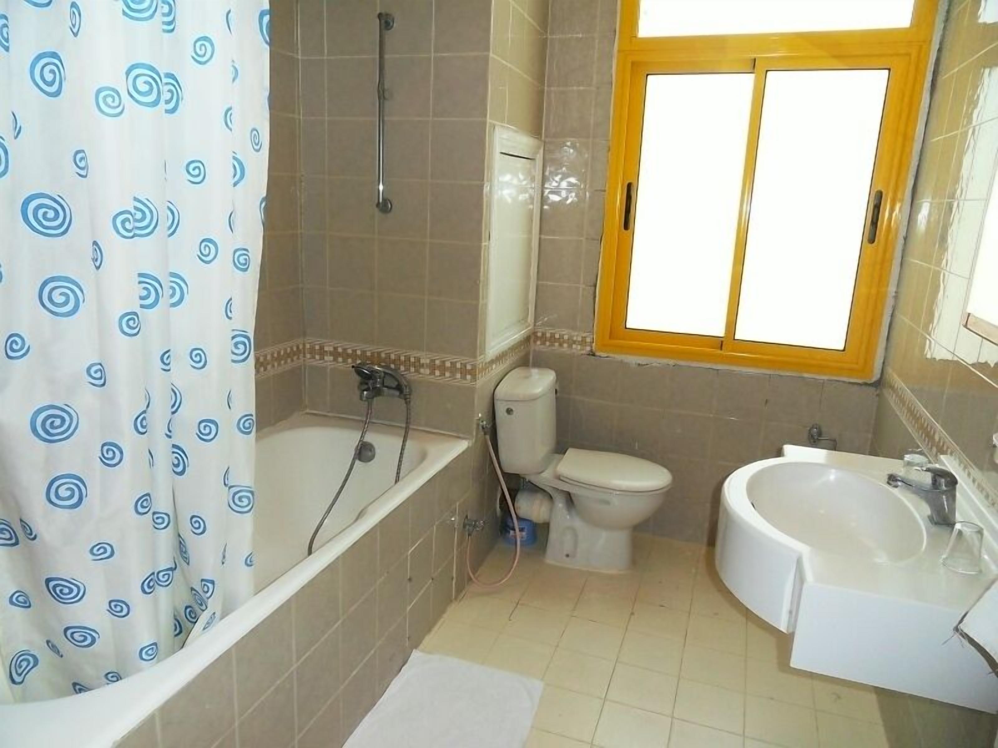 Een badkamer met een bad, toilet en wastafel.