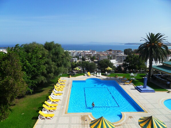 Alberca al aire libre, sombrillas en la alberca y camastros 