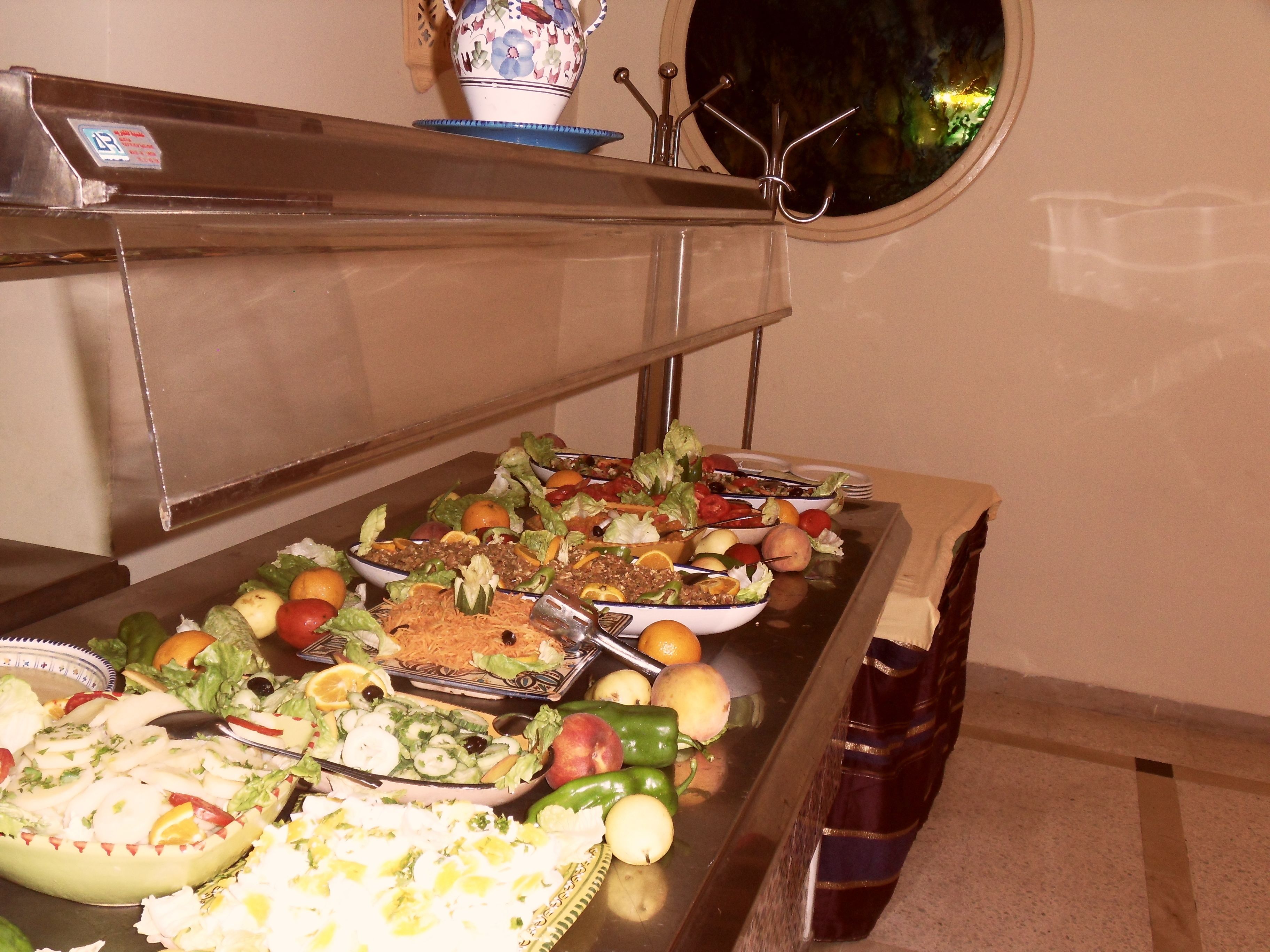 Una mesa de buffet con diversos platos y frutas.