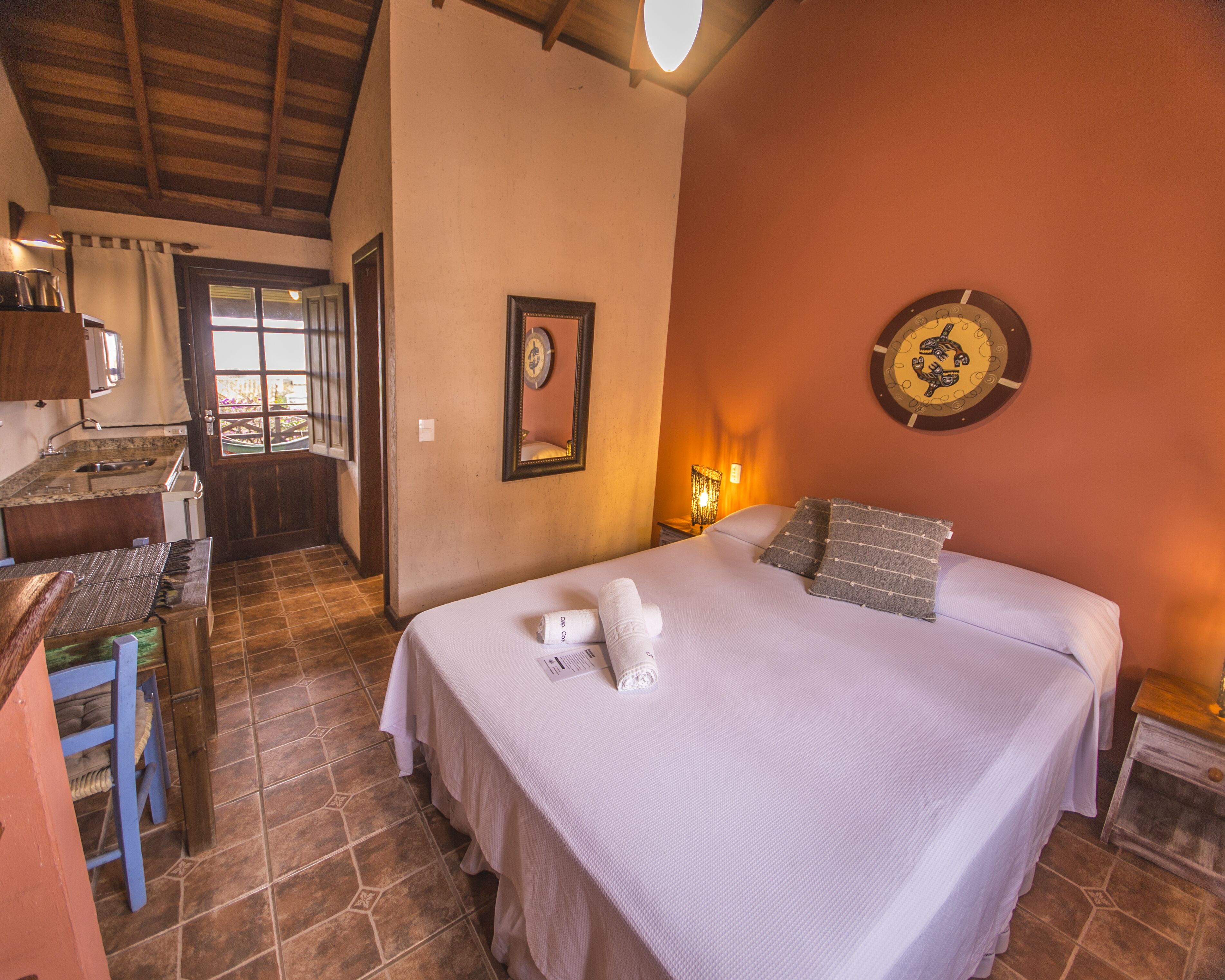 A hotel room with a bed, a desk, and a bathroom.