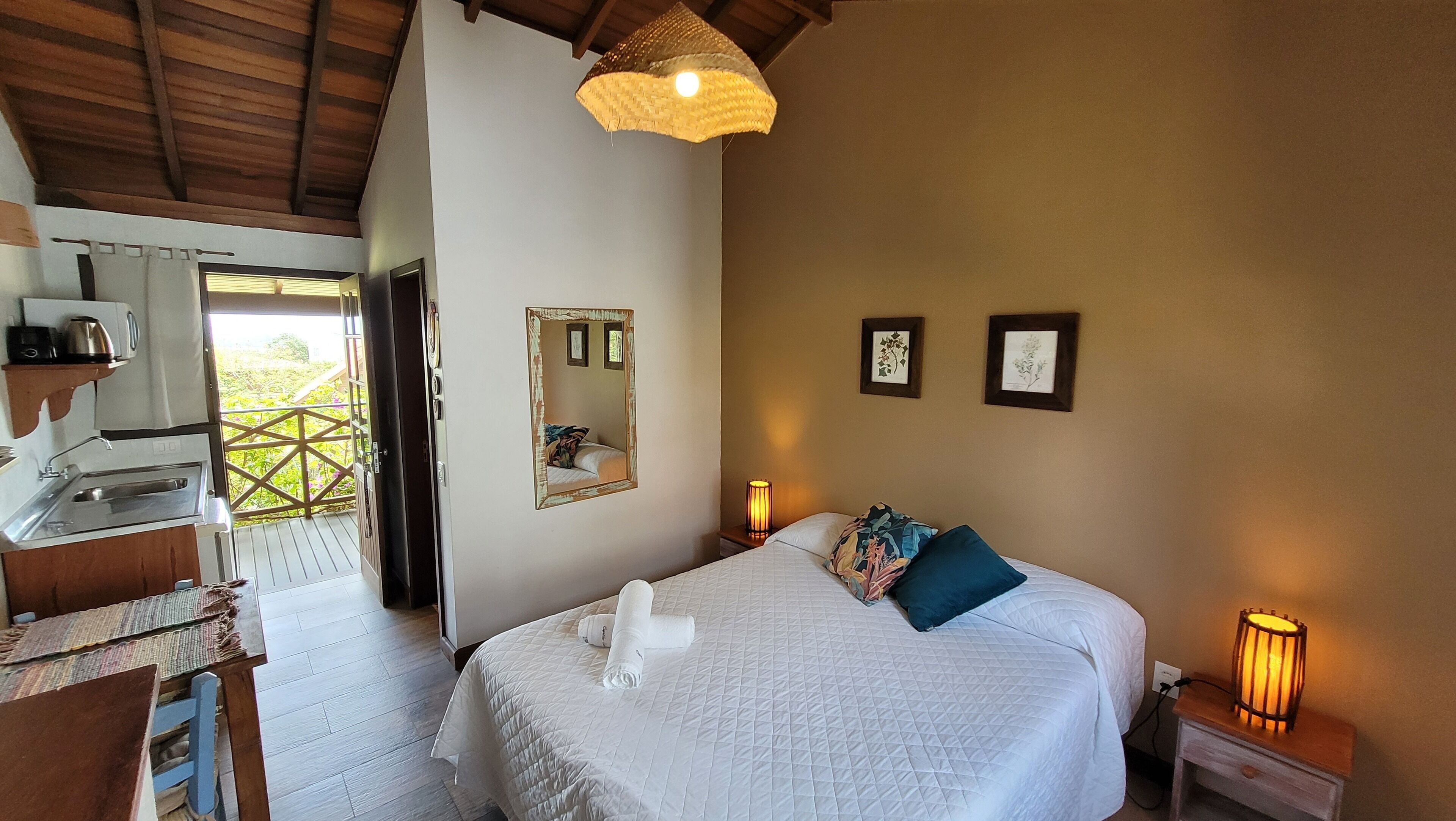 Une chambre à coucher avec un lit, des lampes de chevet, un miroir et une fenêtre.