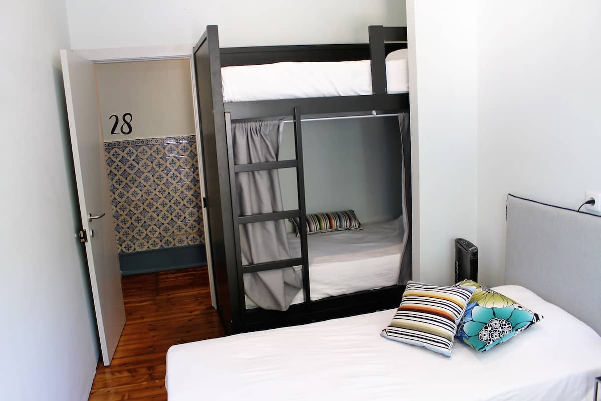 A room with a bunk bed, a door with the number 28, and a patterned wall.