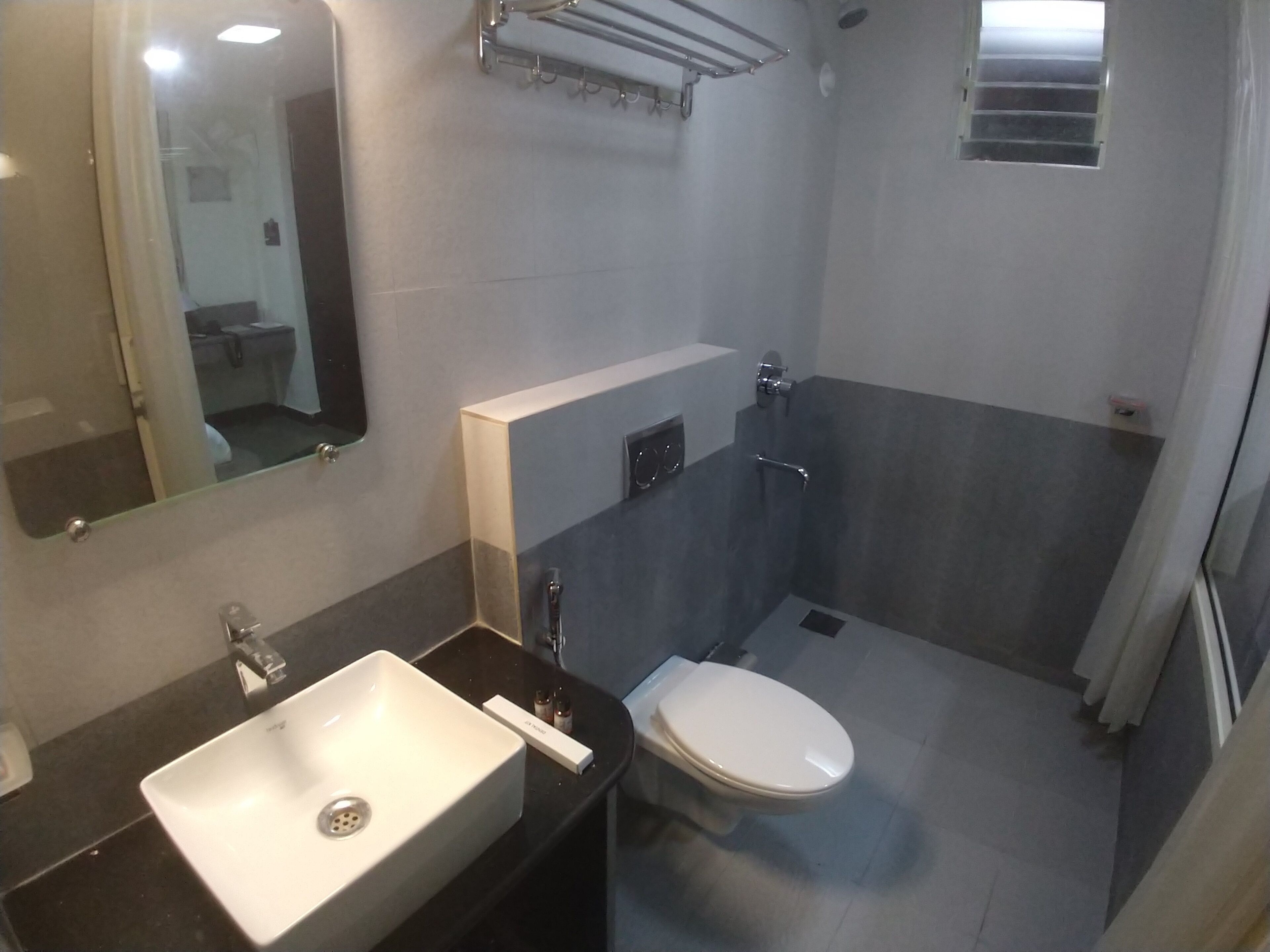 A modern bathroom with a white sink, a toilet, and a shower area.