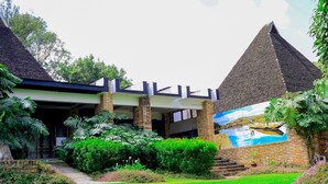 Un edificio con fachada de ladrillo, un acceso cubierto y un mural de un paisaje.