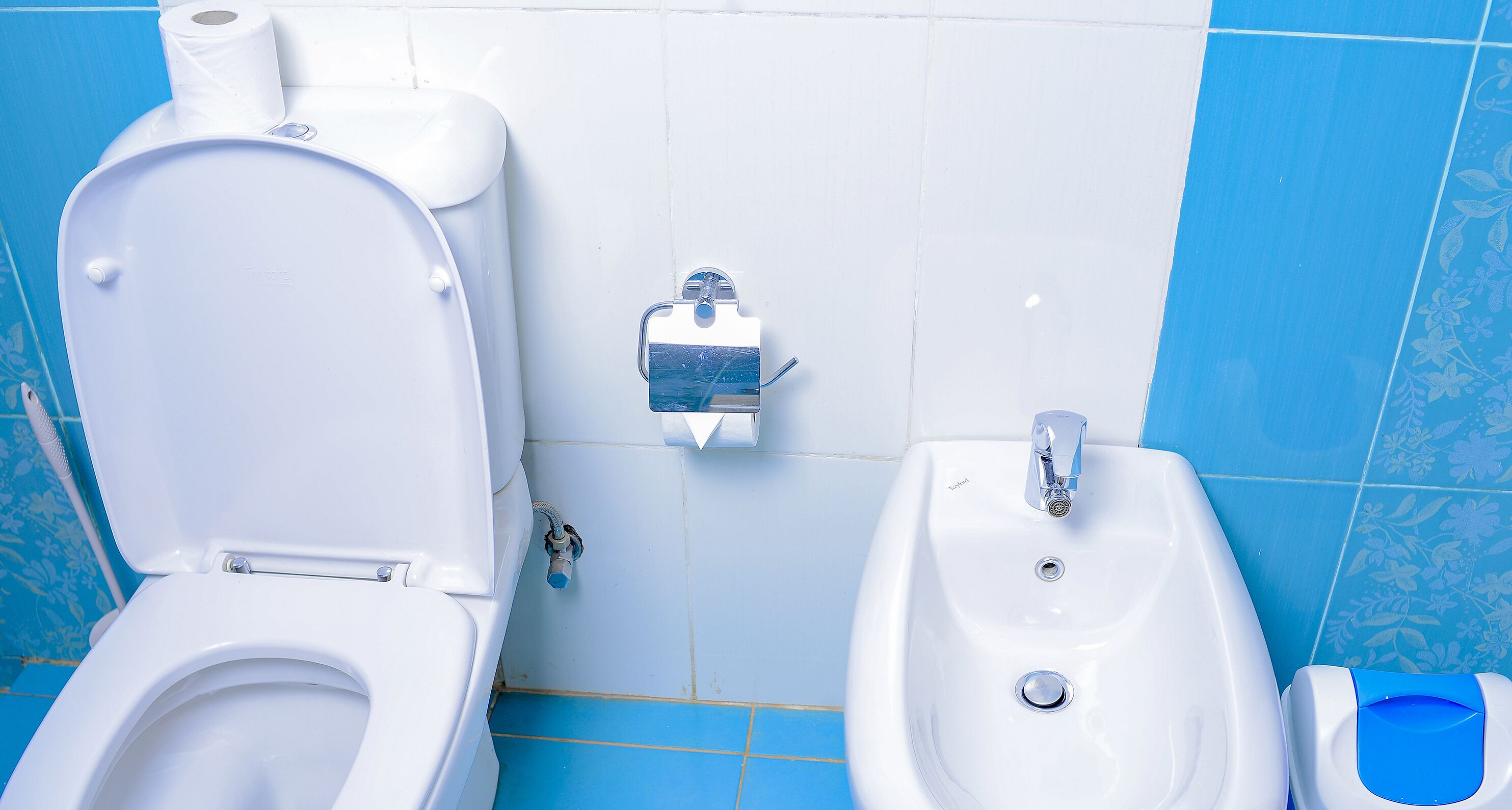 Un baño con inodoro, bidé y lavamanos.