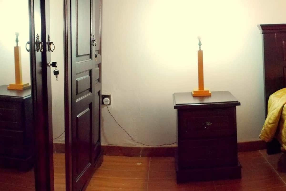 A bedroom with a bed, a nightstand, and a dresser.