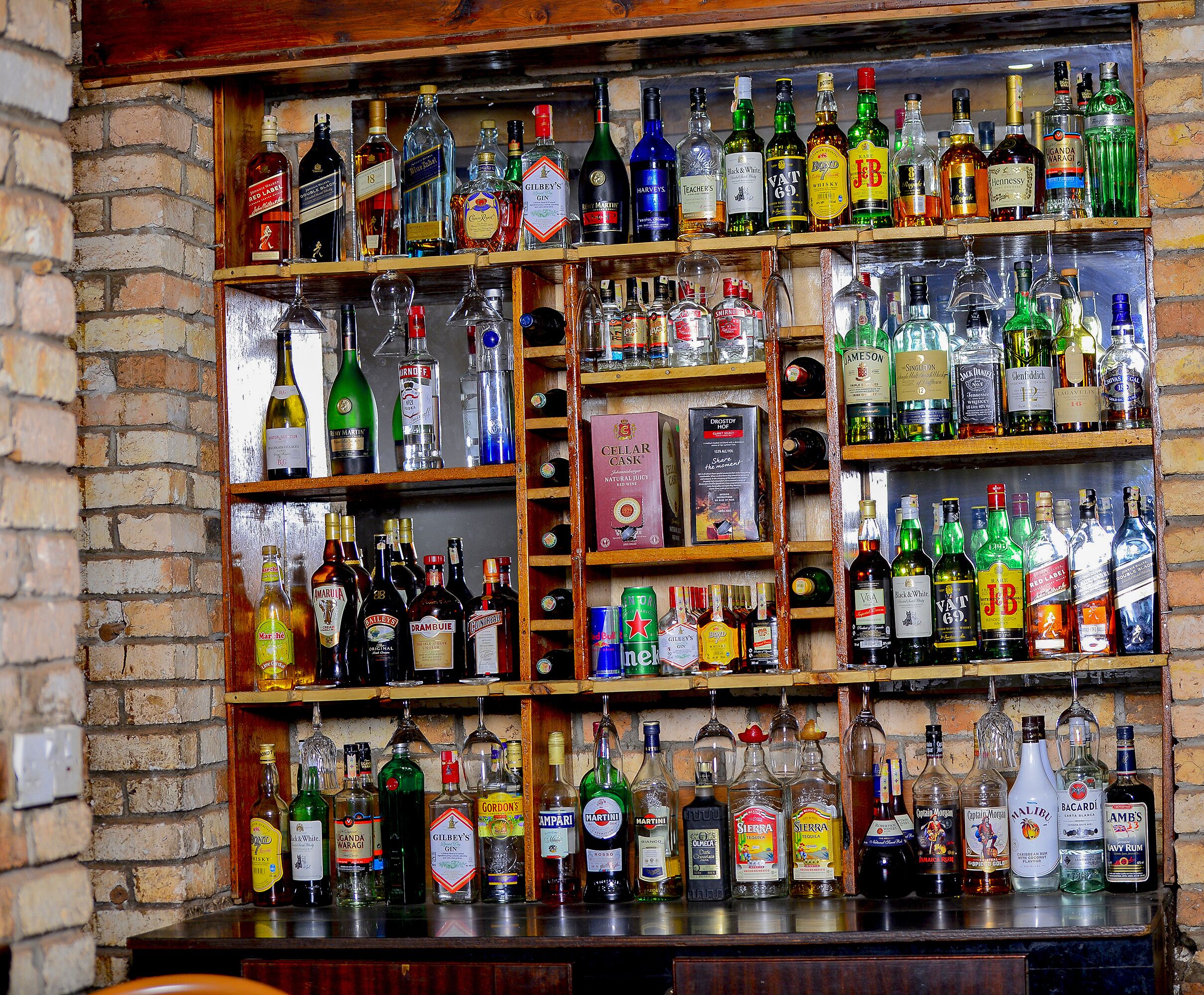 Un bar con estanterías llenas de diferentes botellas de licores.