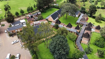 An aerial view of a residential area with multiple houses, a parking lot, and a golf course.