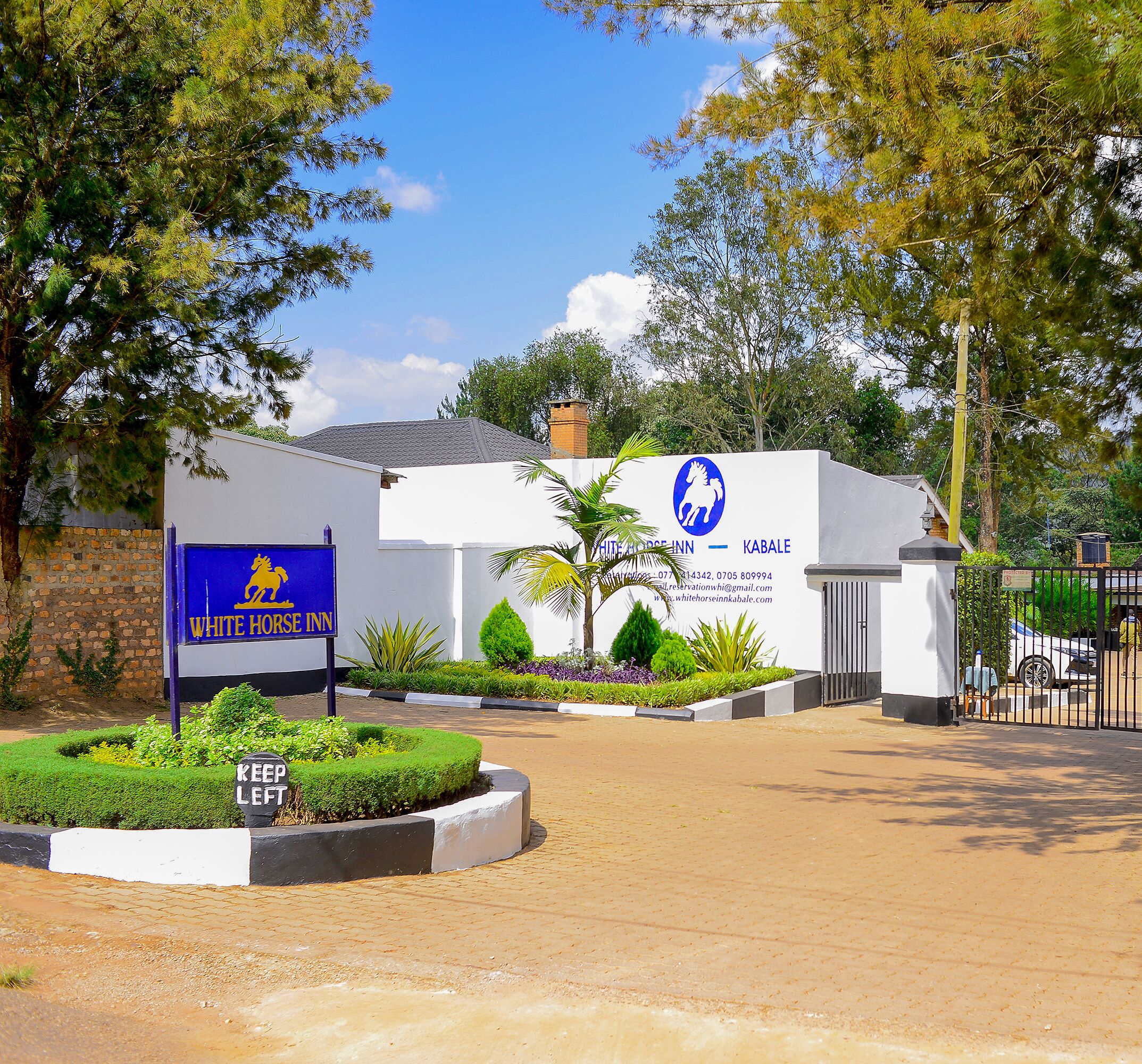 A building with a sign for White Horse Inn and Kabale.