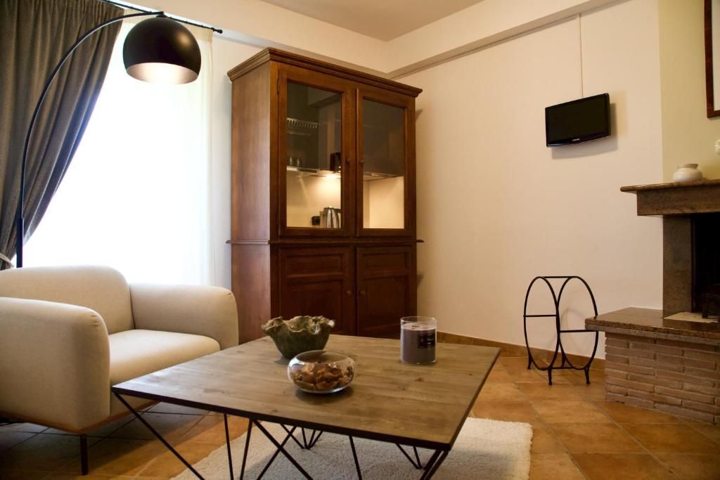Een woonkamer met een bank, een houten kast, een televisie en een open haard.