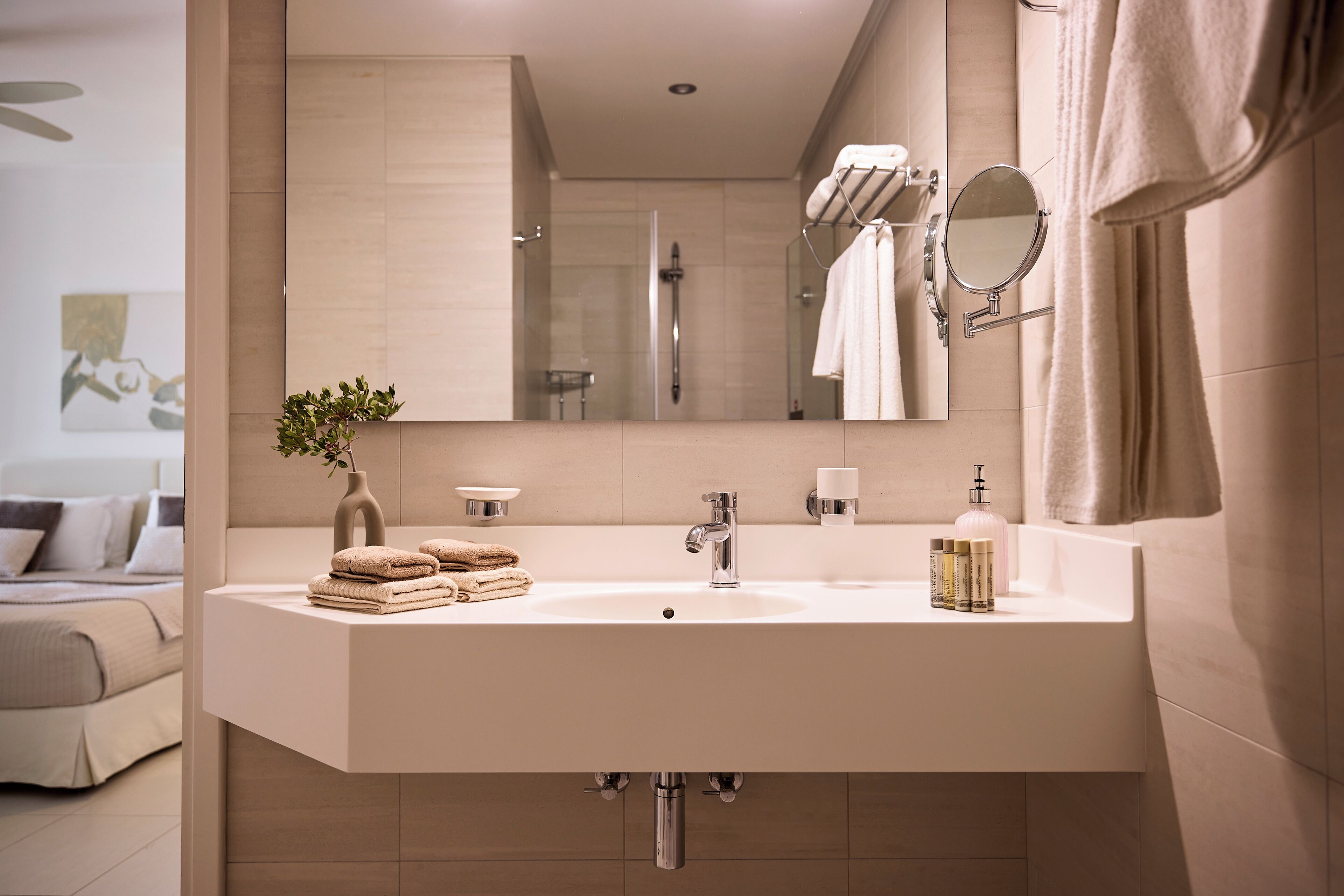 Un baño moderno con un lavabo grande, espejo y perchero para toallas.