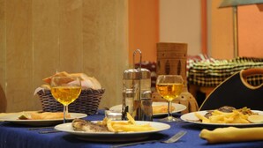 A dining table with plates of food, glasses of wine, and a basket of bread. - Residence Corail Royal Plage (Tabarka)