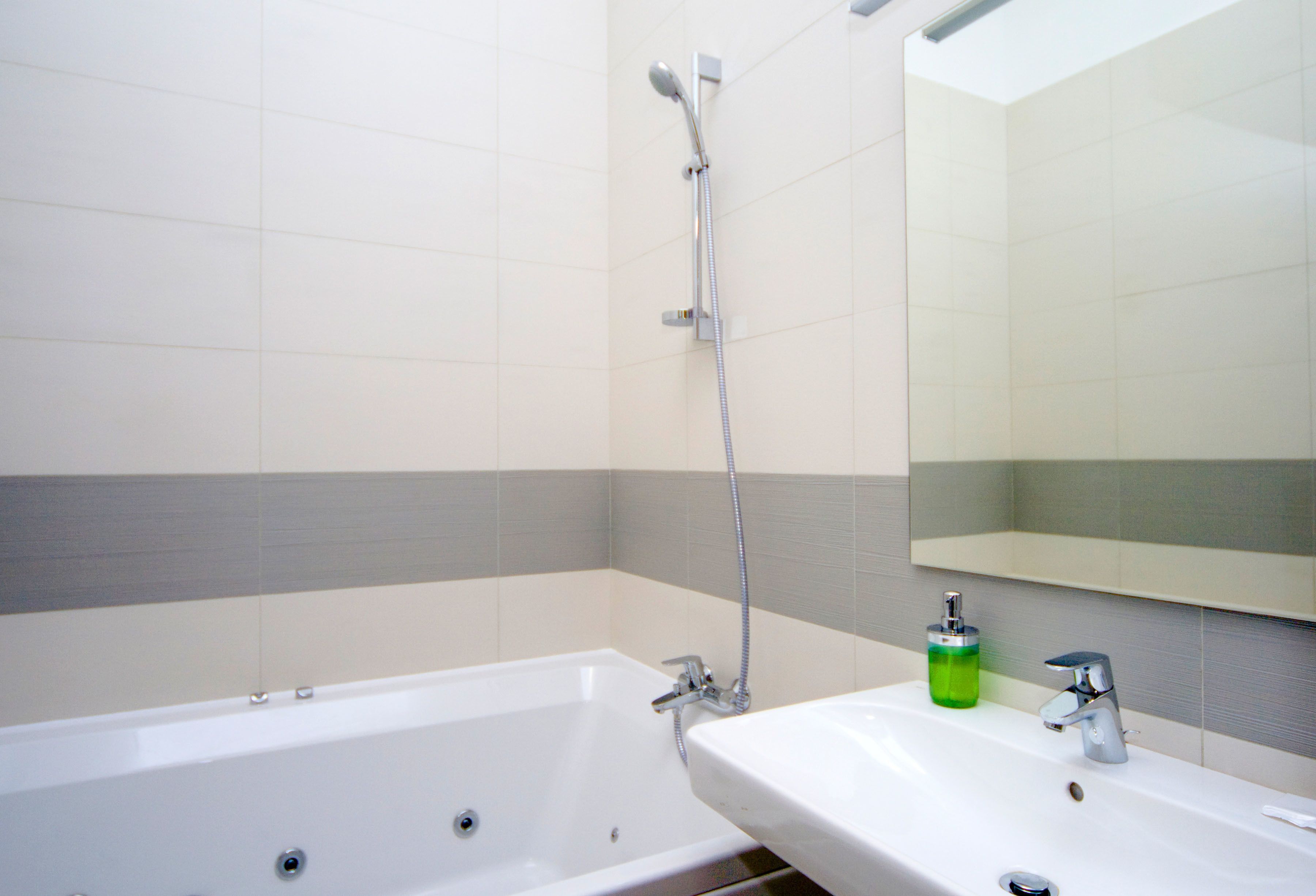 Une salle de bain avec une baignoire, un lavabo et un miroir.