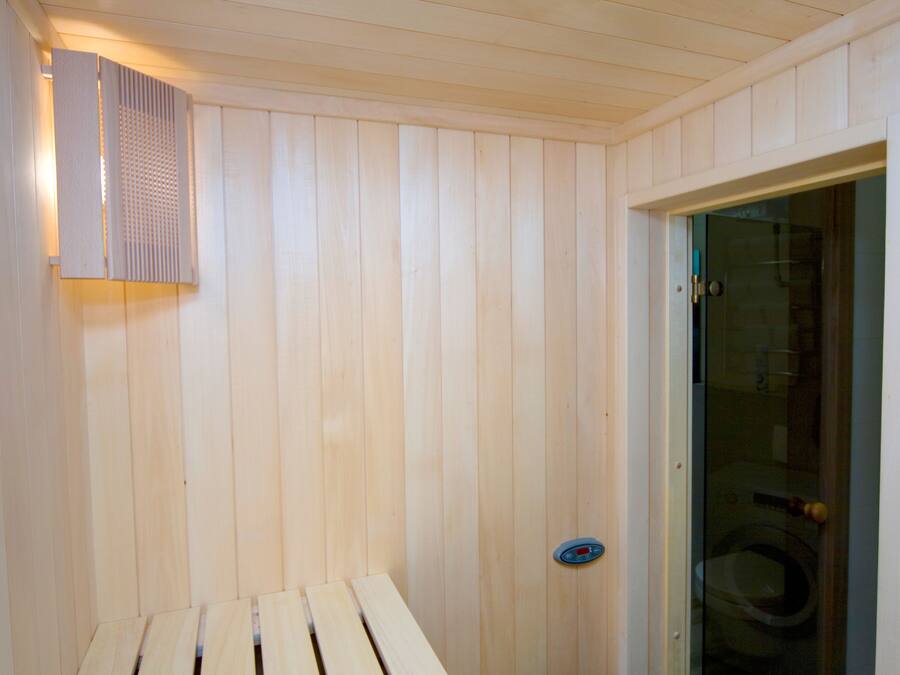 A sauna with wooden walls and a bench.