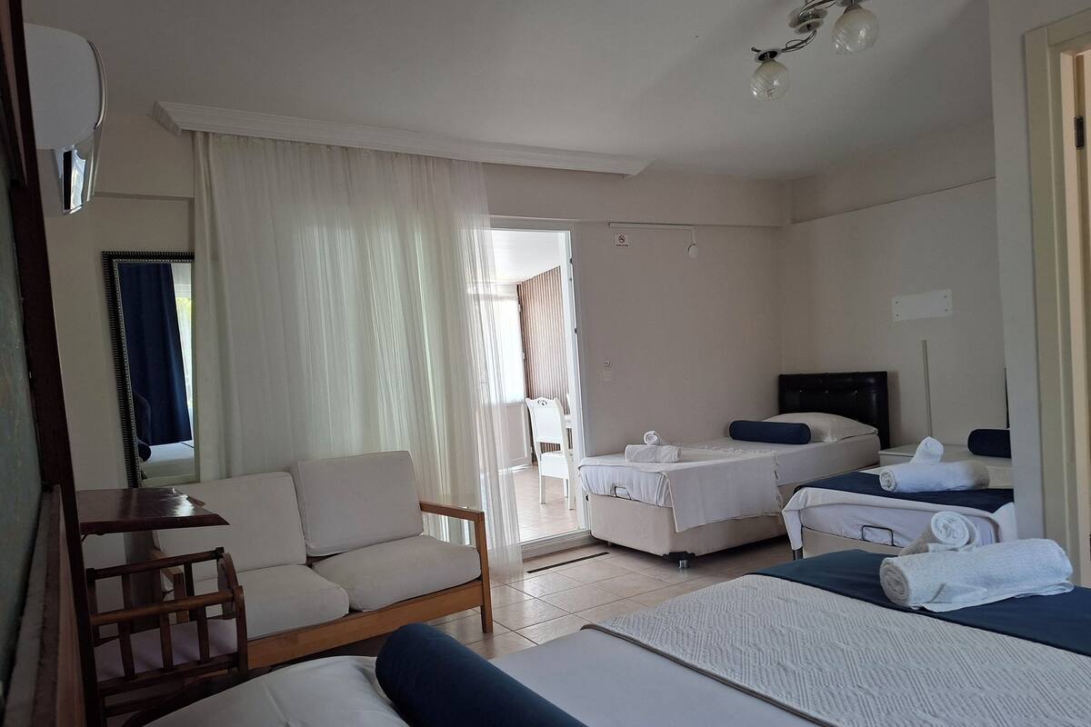 A hotel room with a bed, a sofa, a desk, and a chair.