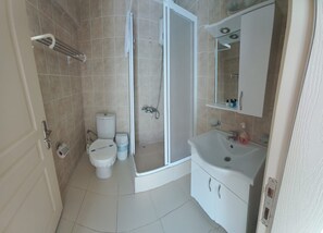 A bathroom with a toilet, shower, and sink. - Hotel Antonio (Cesme)