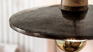Una lámpara colgante con una parte superior de madera y una base metálica.