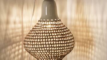 Een hanglamp met een geweven ontwerp, bevestigd aan een muur.