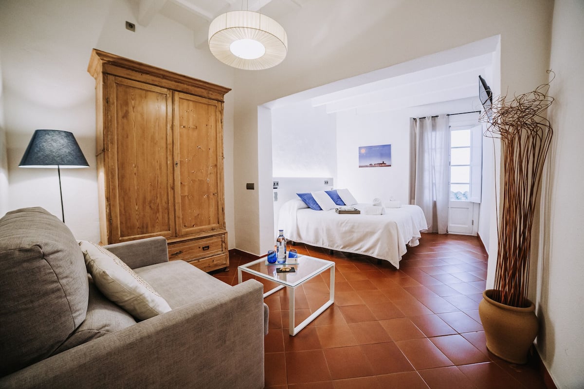 Una sala de estar moderna con un sofá, un mueble de madera y una mesa de centro de vidrio.