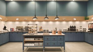 A modern kitchen with blue cabinets, a central island with storage, and overhead lighting.