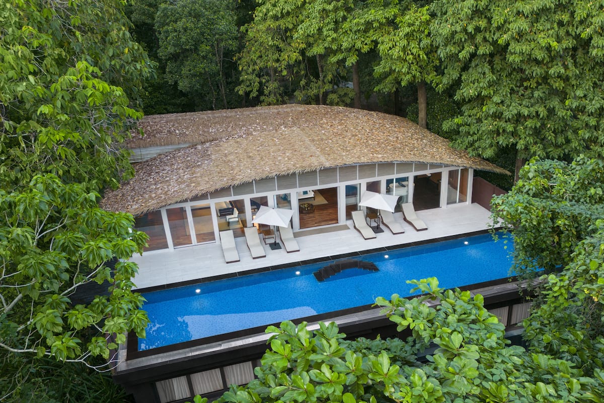 A poolside area with lounge chairs and a covered seating area.