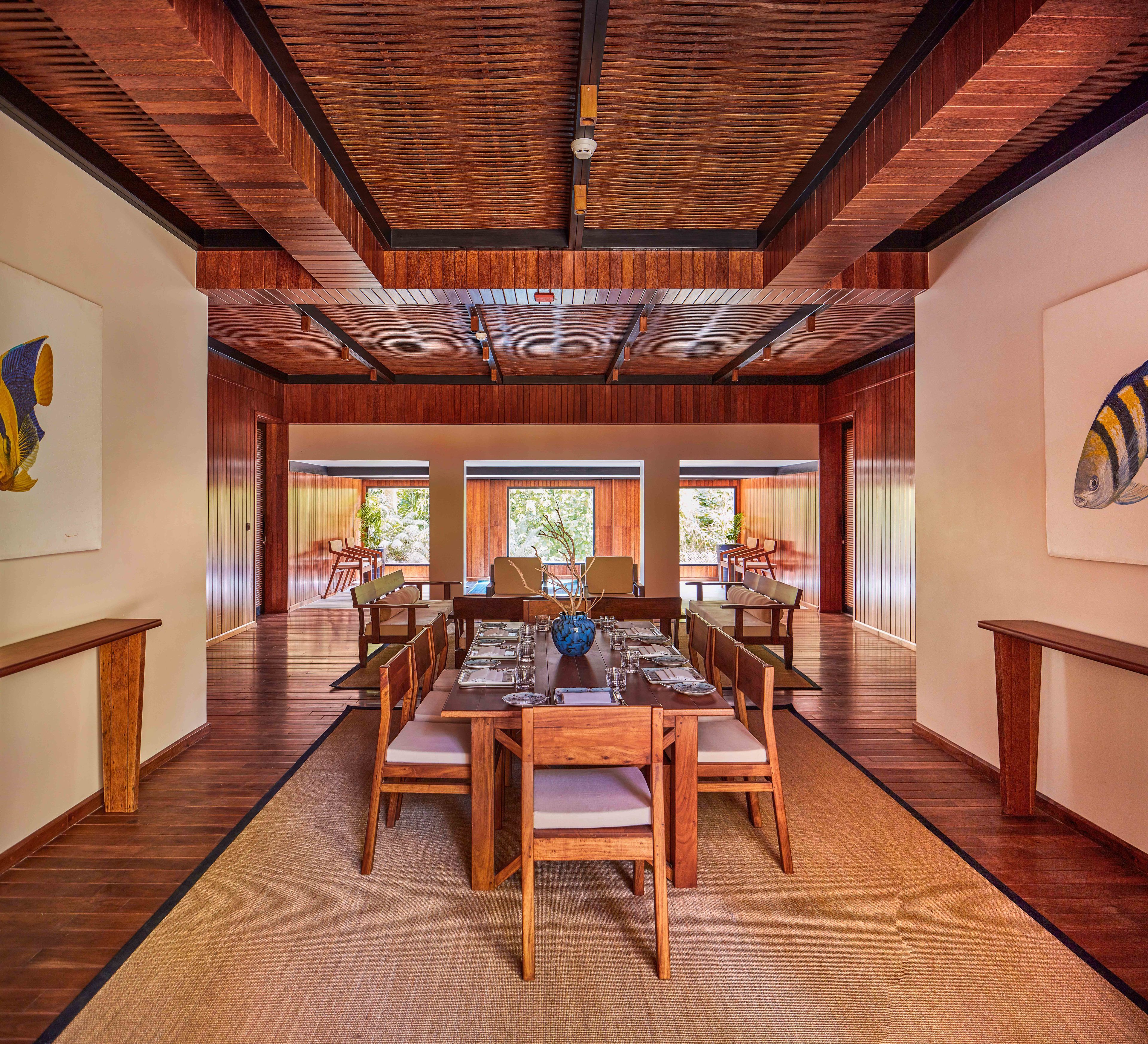A spacious dining area with a long wooden table set for six, surrounded by wooden chairs.