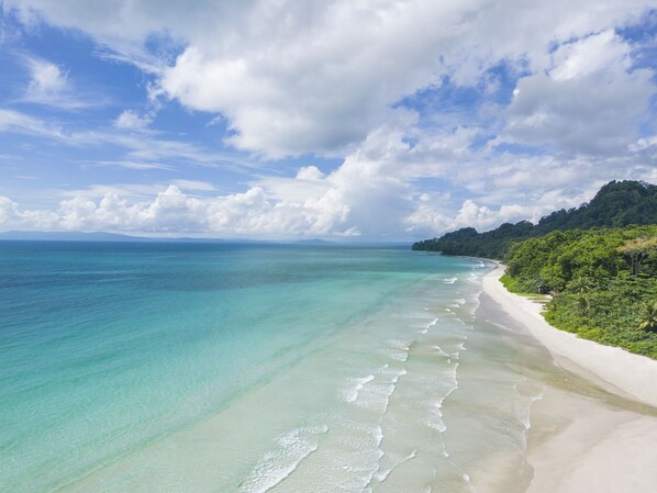 On the beach, white sand, sun loungers, beach umbrellas