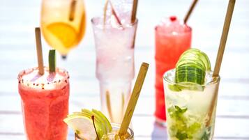 A variety of colorful cocktails on a wooden table.