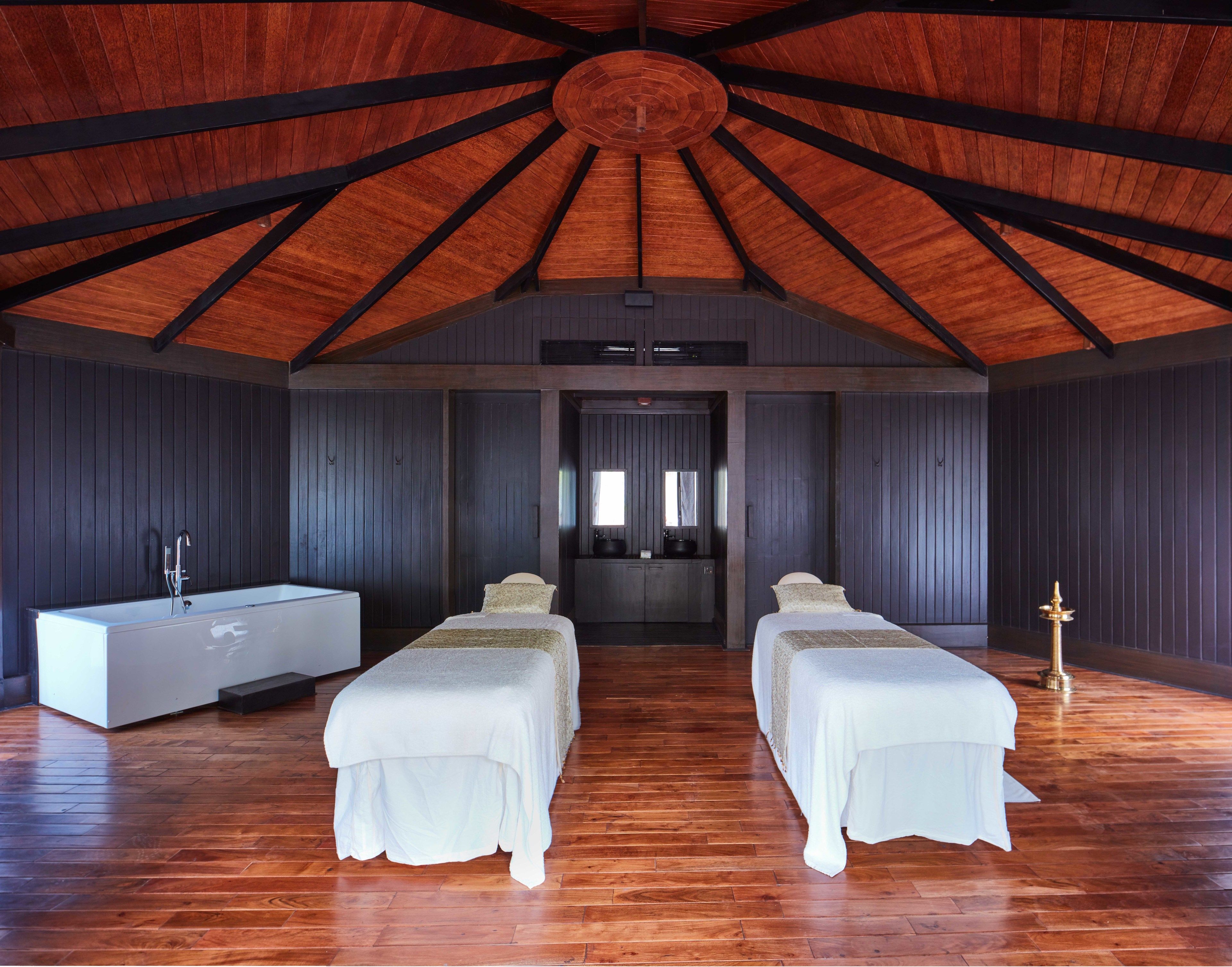 Ruime kamer met hoog houten plafond, twee bedden, een groot raam en een moderne badkamer.
