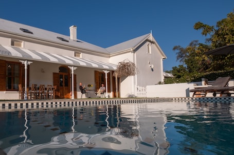 Una piscina al aire libre de temporada, sombrillas