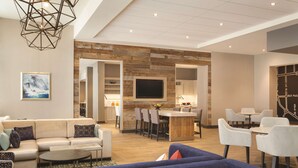 A modern hotel lobby with a seating area, a kitchen, and a dining space. - Hyatt Place Niagara Falls (Niagara Falls)