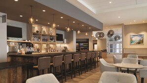 A modern bar area with a long counter, multiple bar stools, and a seating area with round tables and chairs. - Hyatt Place Niagara Falls (Niagara Falls)